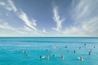 在充满活力的夏日天空下，冲浪者聚集在绿松石水域
