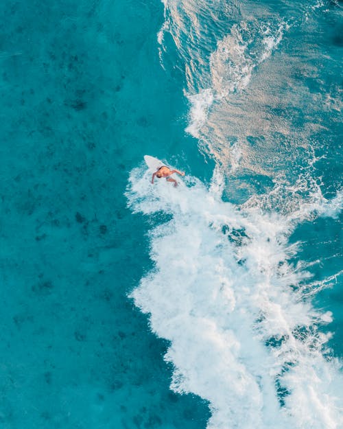 A Person Surfing on the Blue Sea 