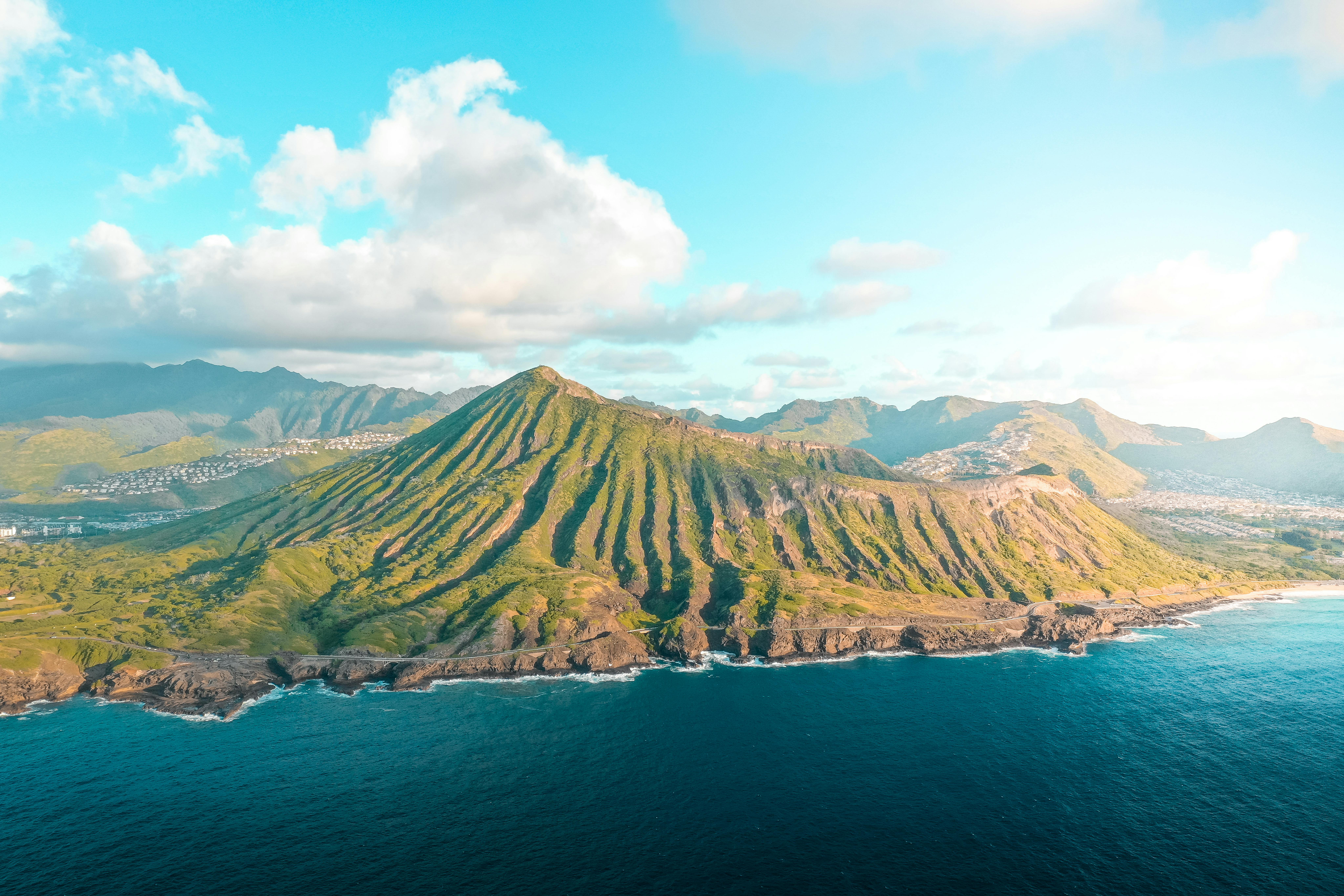 从空中俯瞰，沿海山脉郁郁葱葱，海浪拍岸，景色壮丽