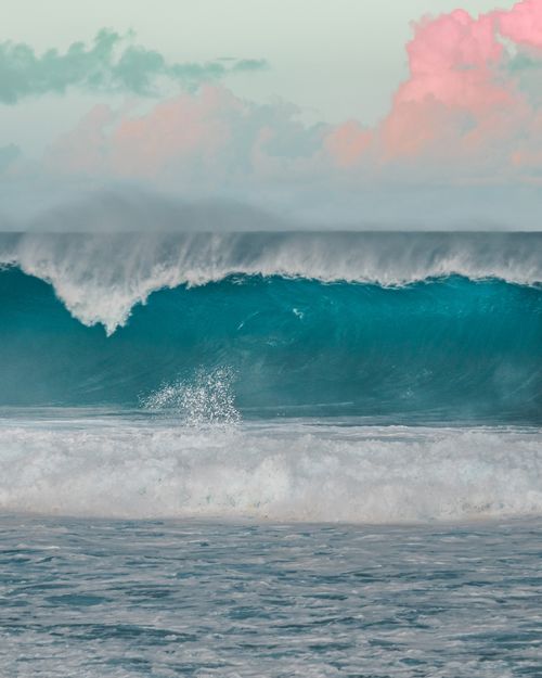 Free Captivating image of an ocean wave contrasting against serene skies and pink clouds. Stock Photo