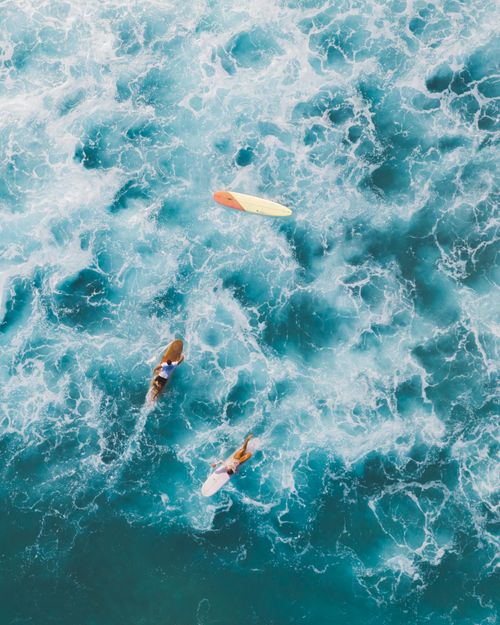 Free Dynamic aerial shot capturing surfers navigating the turquoise sea with vivid waves. Stock Photo