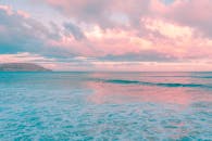 日落时，粉红色和蓝色的色调在岛屿海景上融合，营造出宁静和热带的氛围