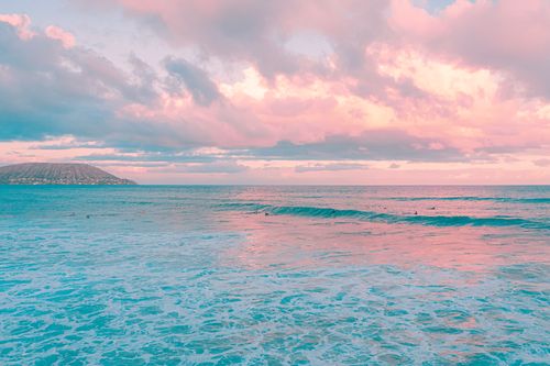 Free Pink and blue hues merge over an island seascape during sunset, creating a serene and tropical atmosphere. Stock Photo