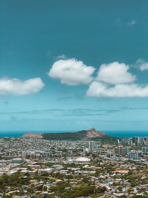 City Buildings Under White Clouds on Blue Sky