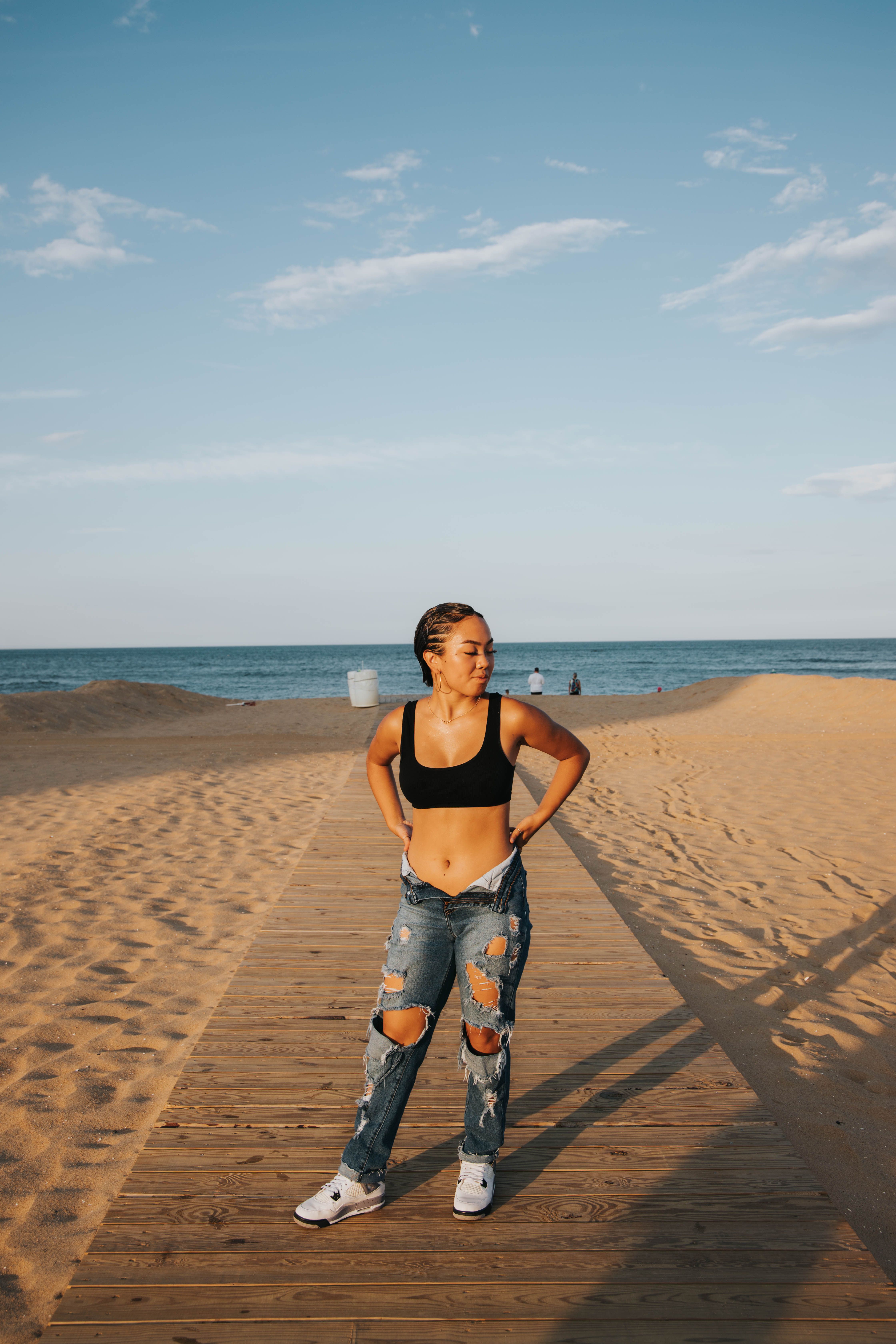 Young Woman Posing on Sunny Beach Boardwalk · Free Stock Photo