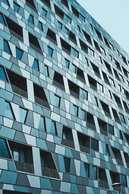 Free Futuristic skyscraper exterior with geometric glass windows in Singapore. Stock Photo