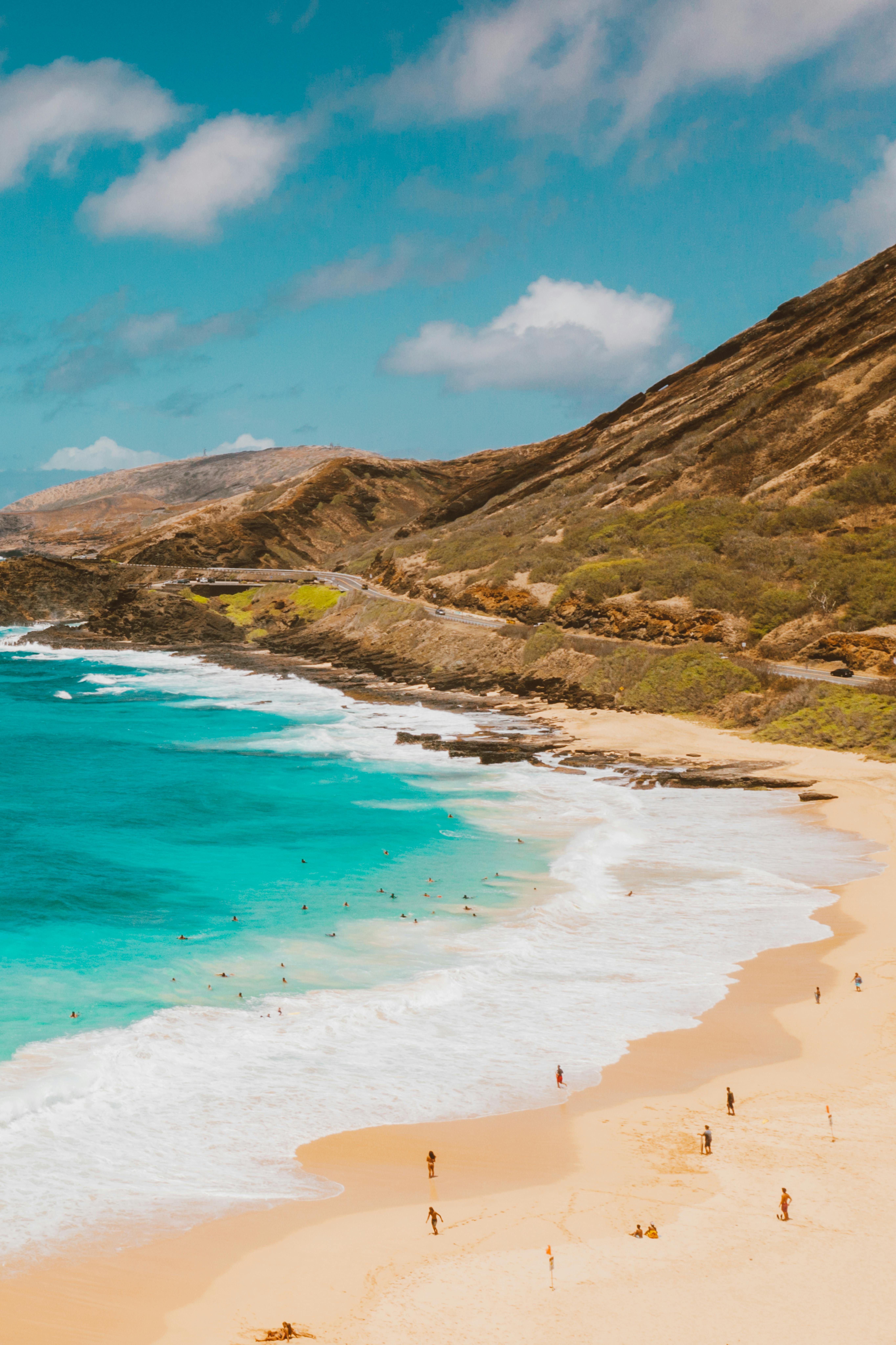 湛蓝的天空下，沙滩上绿松石般的海水与岩石悬崖构成壮丽景色