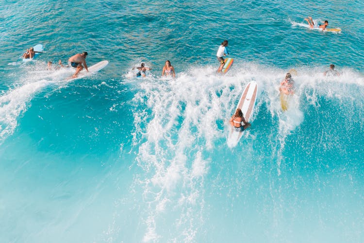 People Surfing On Big Waves Of The Sea