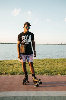A stylish man roller skating by the water on a sunny day, embodying summer vibes.