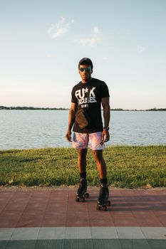 Young man roller skating by a serene lakeside during a bright summer day.
