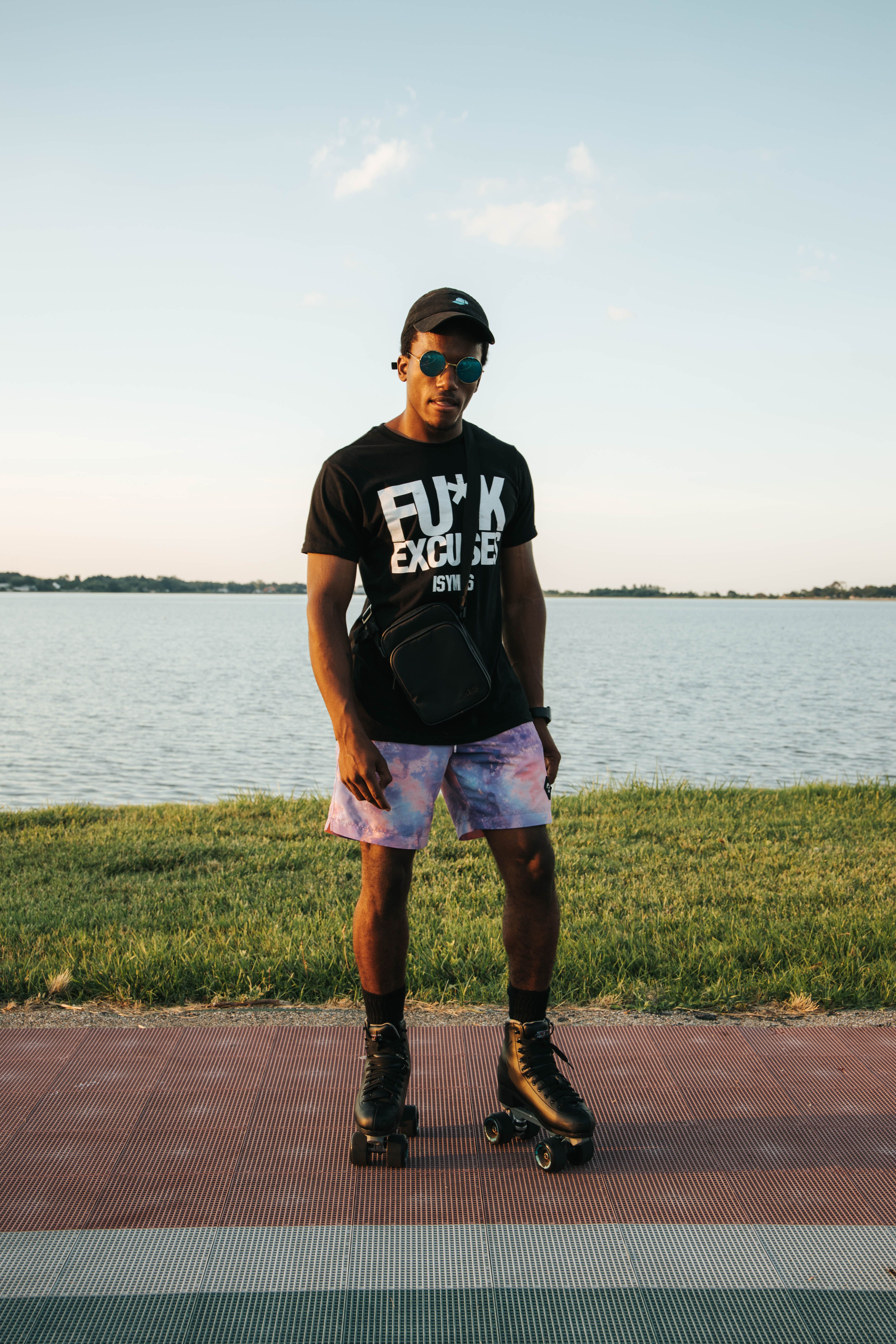 A young man enjoys roller skating by the lakeside on a sunny summer day.