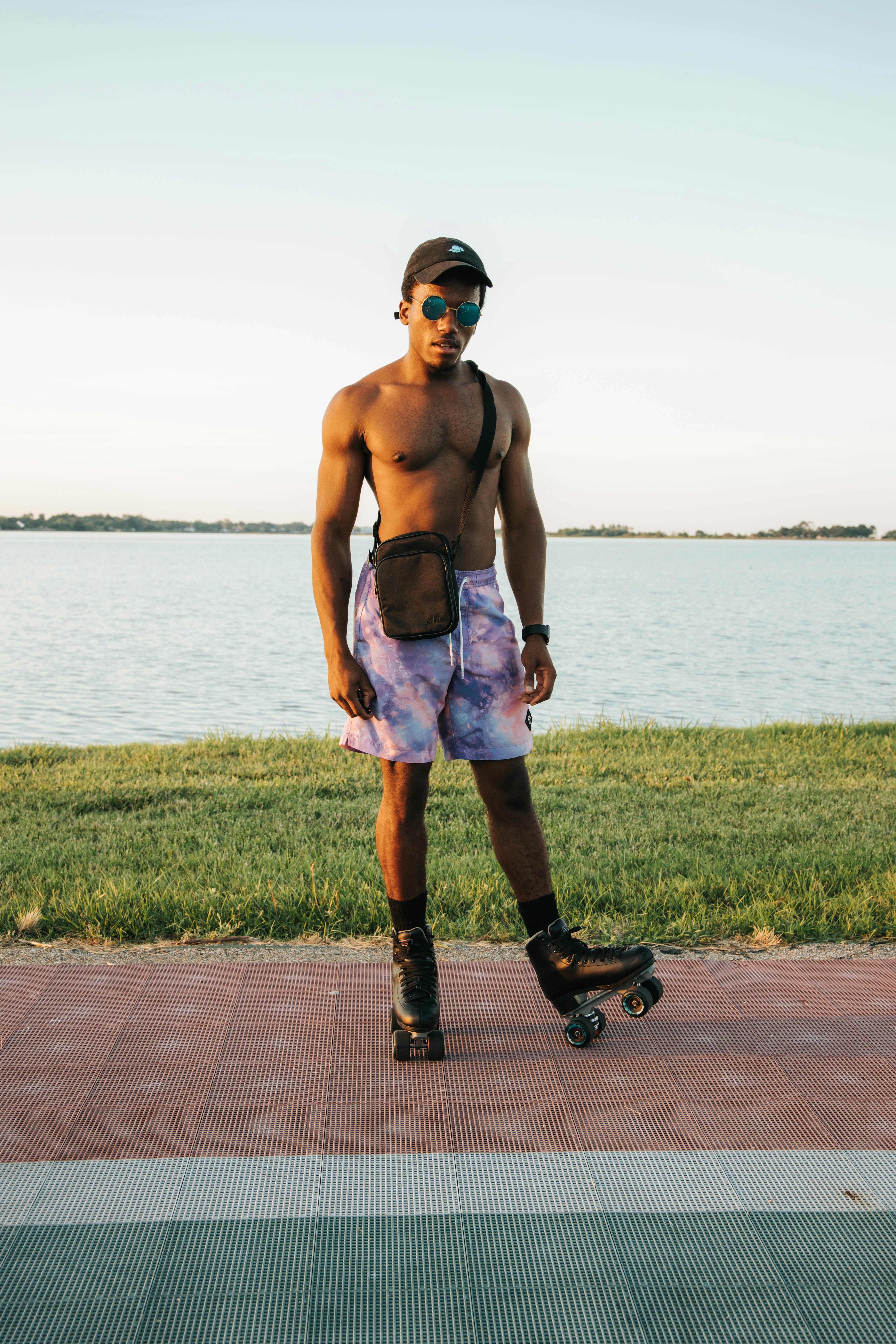 Shirtless Man in Shorts Wearing Roller Skates Free Stock Photo