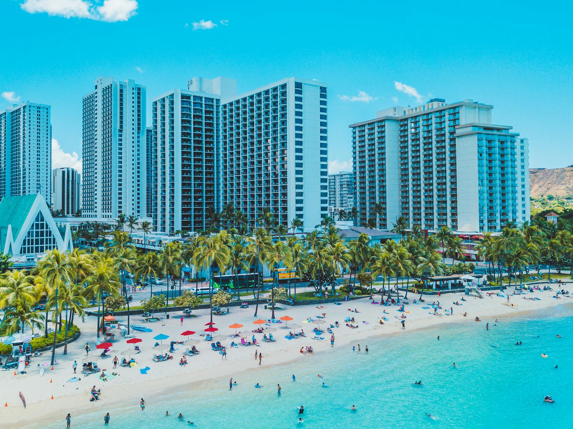 Stunning aerial view of Waikiki Beach with high-rise hotels and sunny beachgoers.