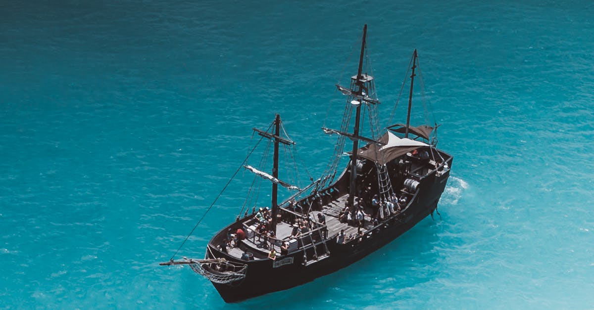 Photo by Jess Loiterton A picturesque view of a pirate ship on a vibrant turquoise ocean near Waimea, Hawaii.