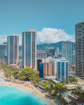 Beautiful aerial shot of Honolulu's skyline and vibrant coastline on a sunny day.