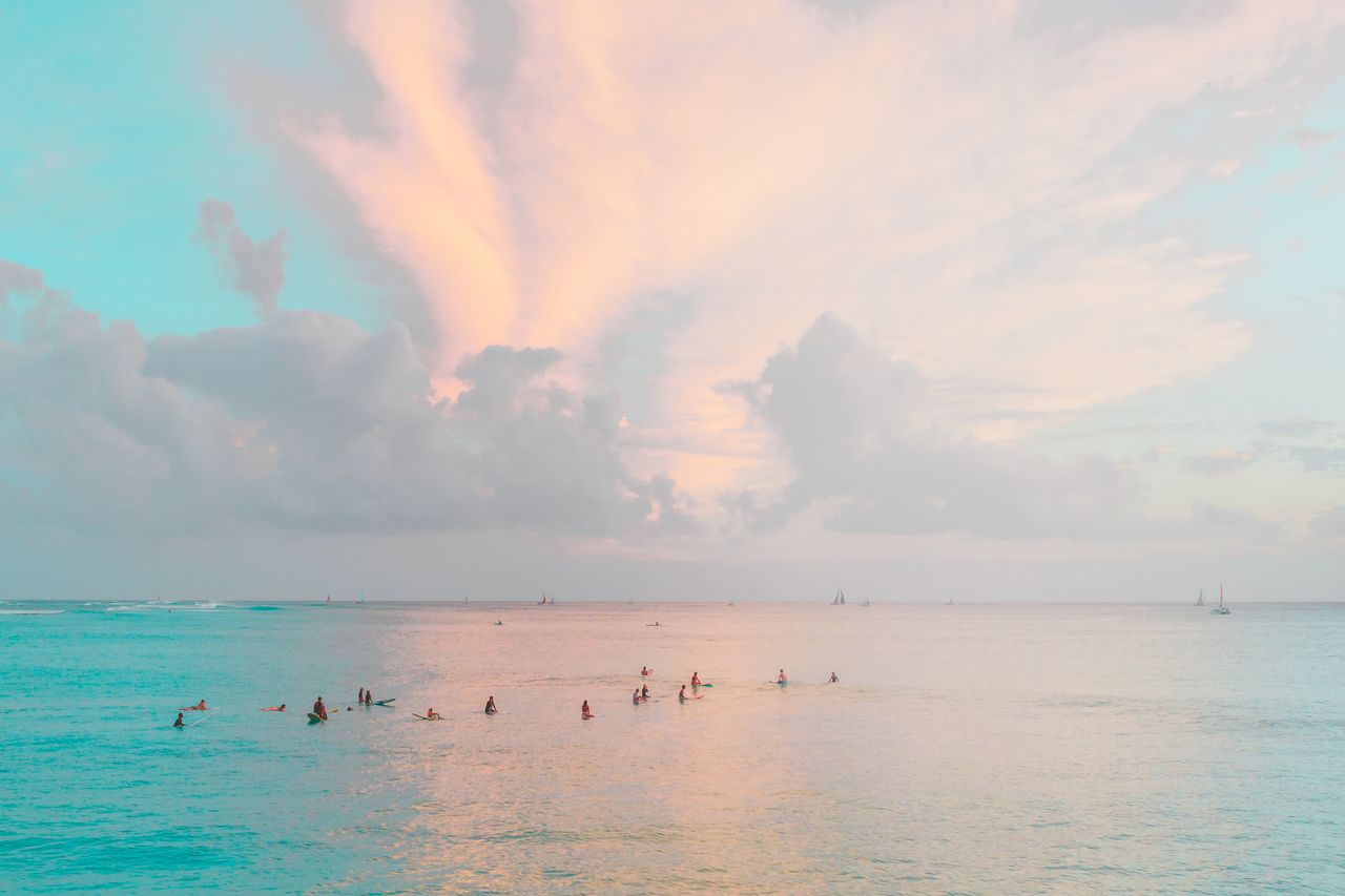surfers enjoying a peaceful evening session on calm ocean waters under