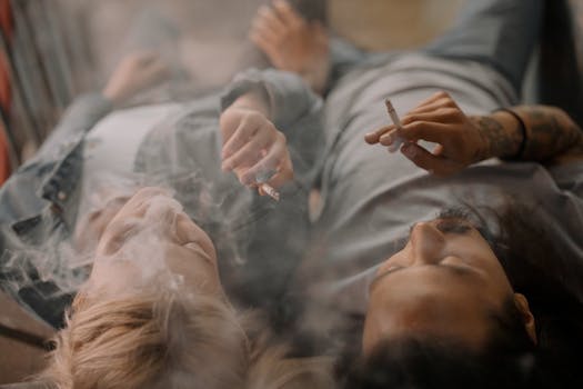 一对夫妇轻松地躺在地板上，抽着烟，享受着彼此的陪伴