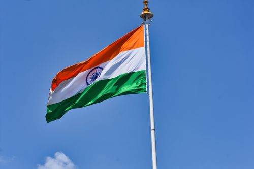 Free The Indian national flag waving against a clear blue sky symbolizes patriotism and national pride. Stock Photo