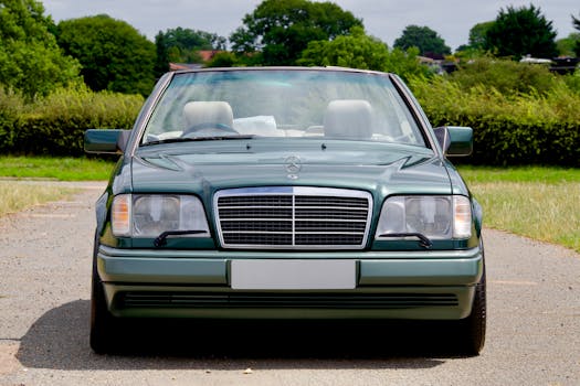 A vintage green Mercedes-Benz convertible parked on a rural road in the UK, capturing a luxurious and classic vibe.