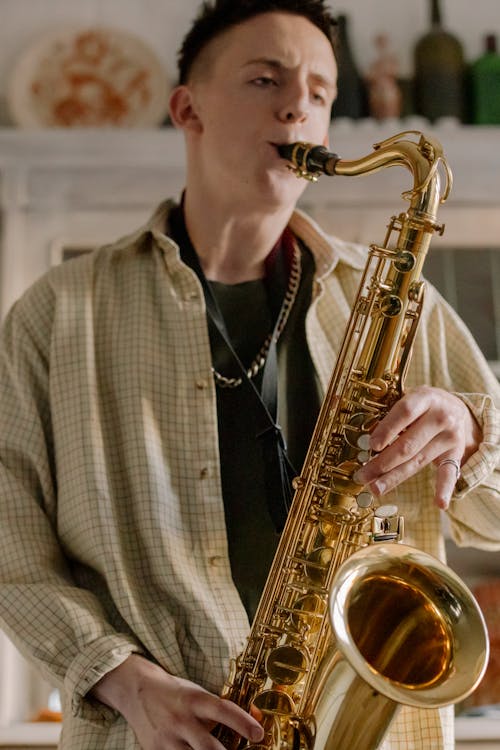 Man in Black and White Plaid Button Up Shirt Playing Saxophone