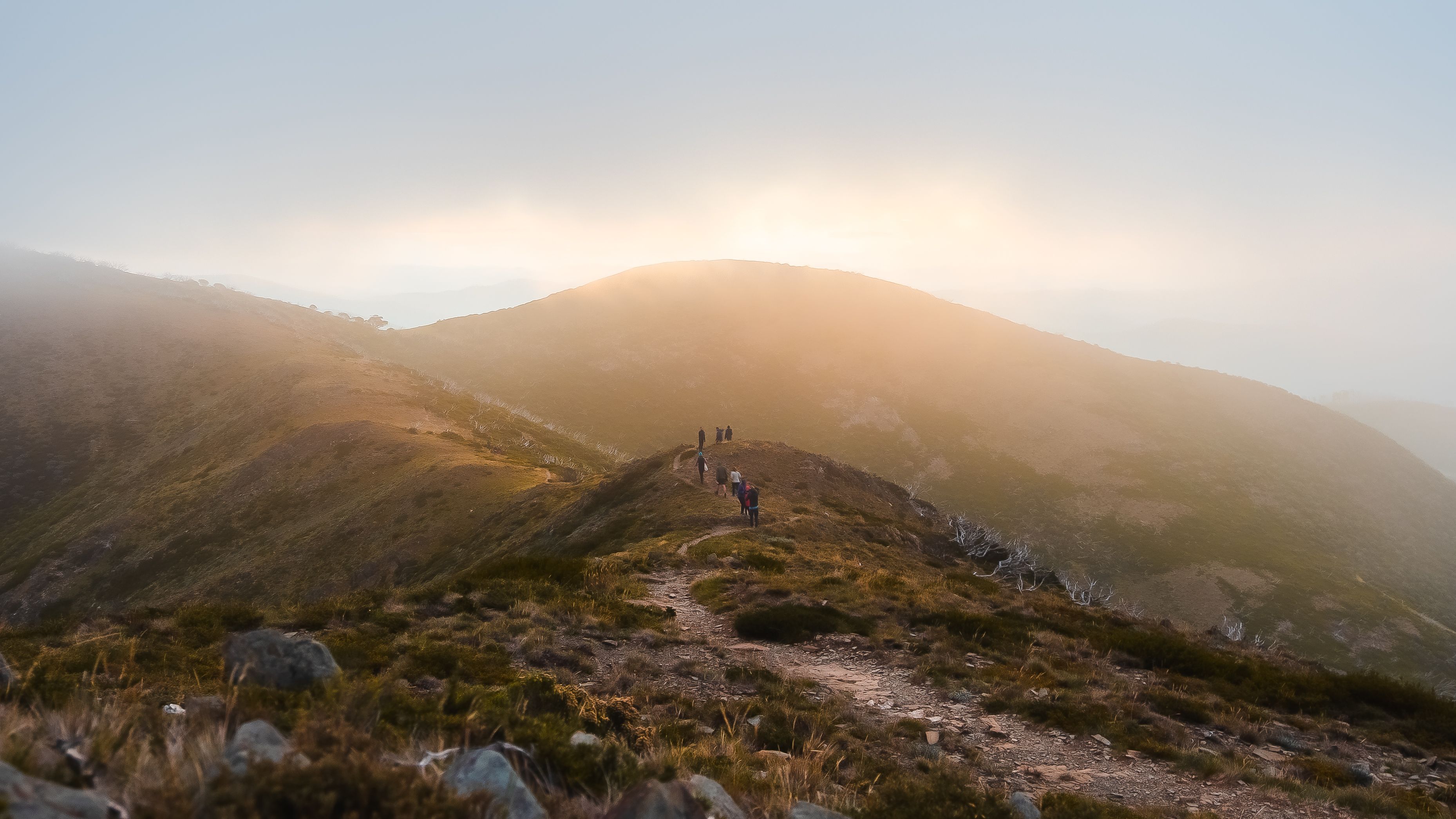 Scenic sunset view of hikers on a mountain trail at Hotham Heights, Australia.