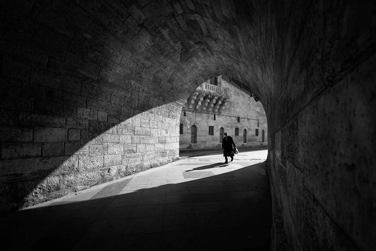 Man Walking In Tunnel Of Old Castle