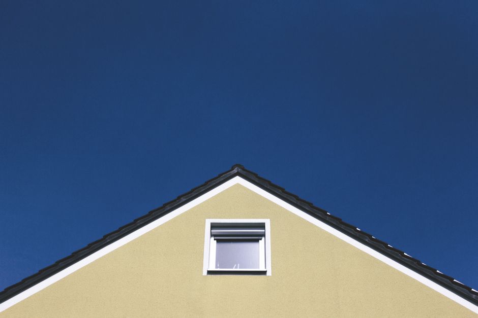 A modern house gable against a clear blue sky, highlighting minimalistic architectural design.