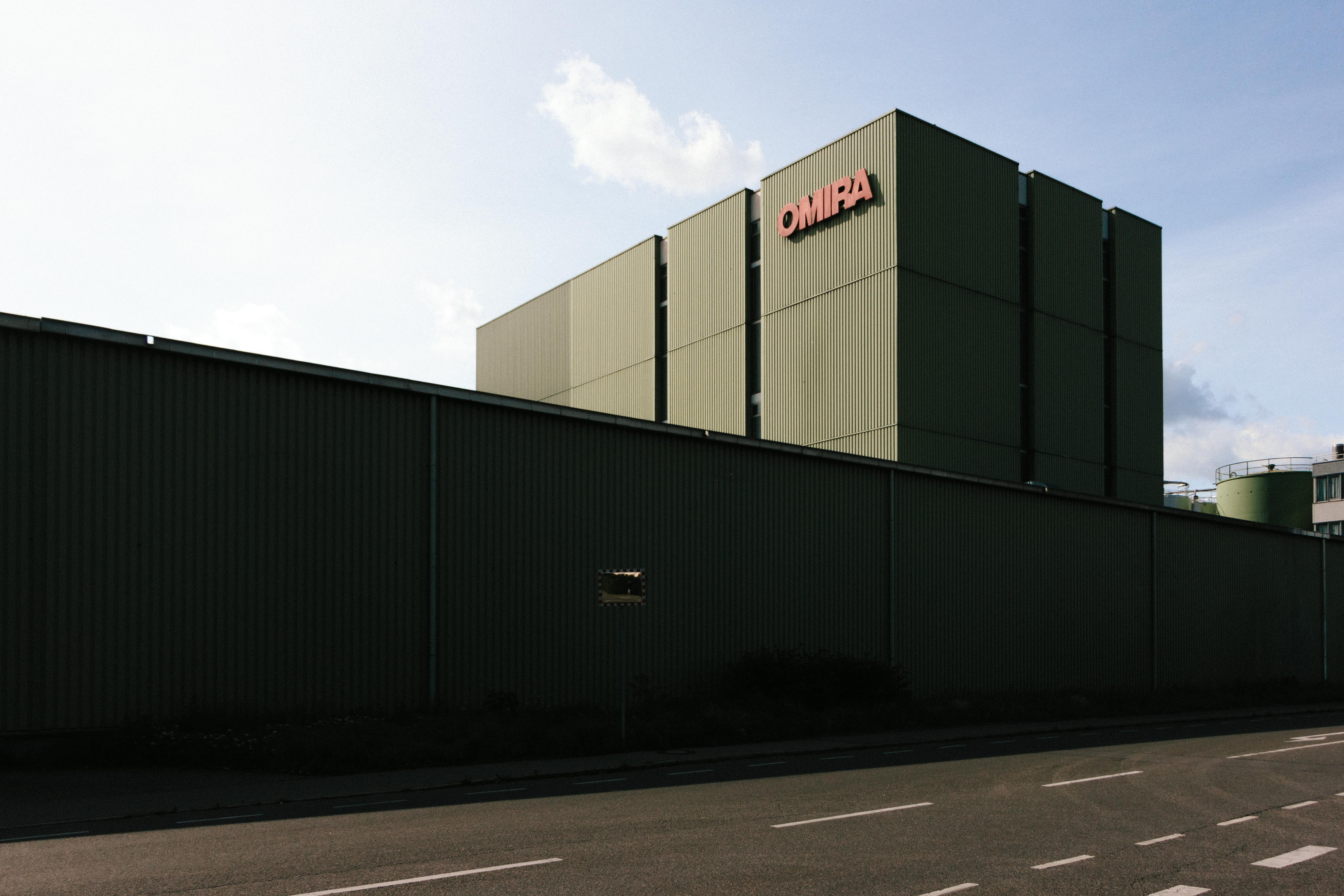 A modern industrial building with a large metal facade under a clear sky.