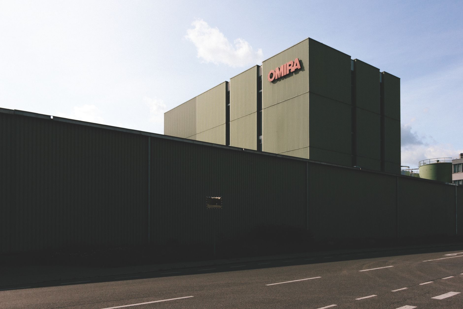 A modern industrial building with a large metal facade under a clear sky.