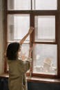 Woman in White Shirt Looking Out the Window