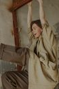 穿着米色风衣的女人在室内洋溢着幸福和活力