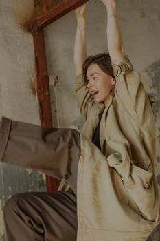 穿着米色风衣的女人在室内洋溢着幸福和活力
