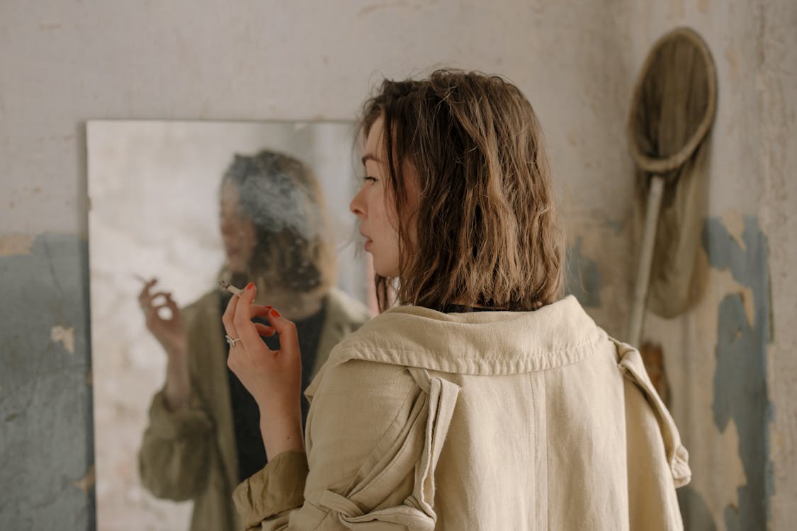 Woman in Beige Coat Holding Her Hair