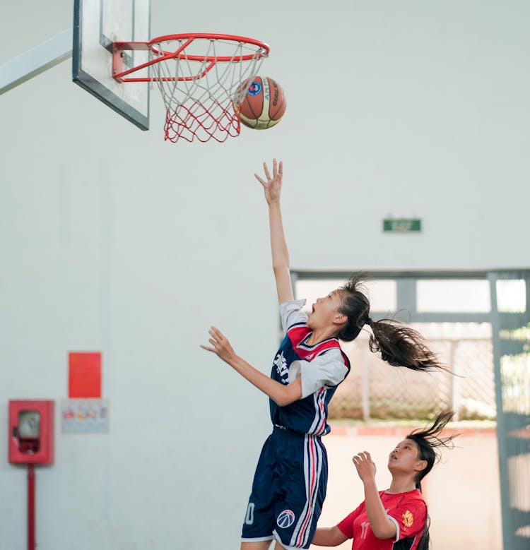 Woman Throwing Basketball Ball In Hoop