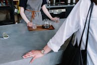 一位咖啡师在时尚的咖啡馆里为顾客倒咖啡的坦诚瞬间