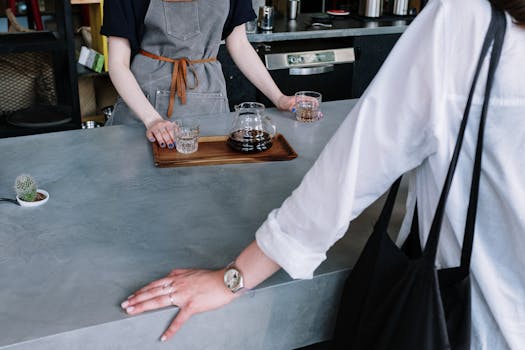 Candid moment of a barista serving pour over coffee to a customer in a stylish cafe.
