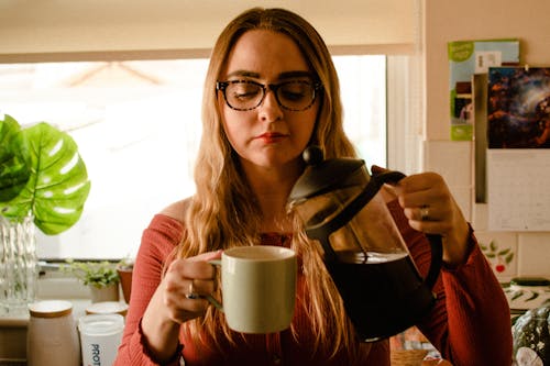 Free A Woman Pouring Coffee on a Cup Stock Photo