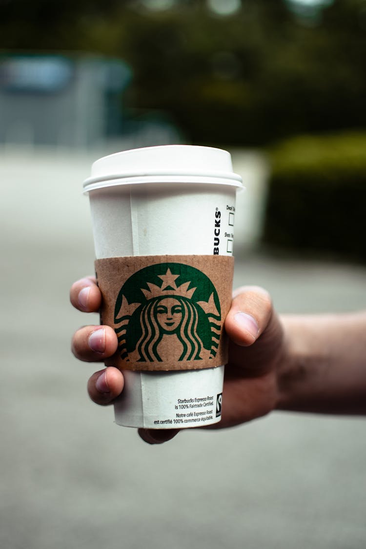 A Person Holding A Hot Starbucks Coffee