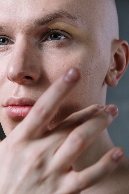 Free Elegant close-up of a man applying makeup, emphasizing beauty routine and cosmetics. Stock Photo