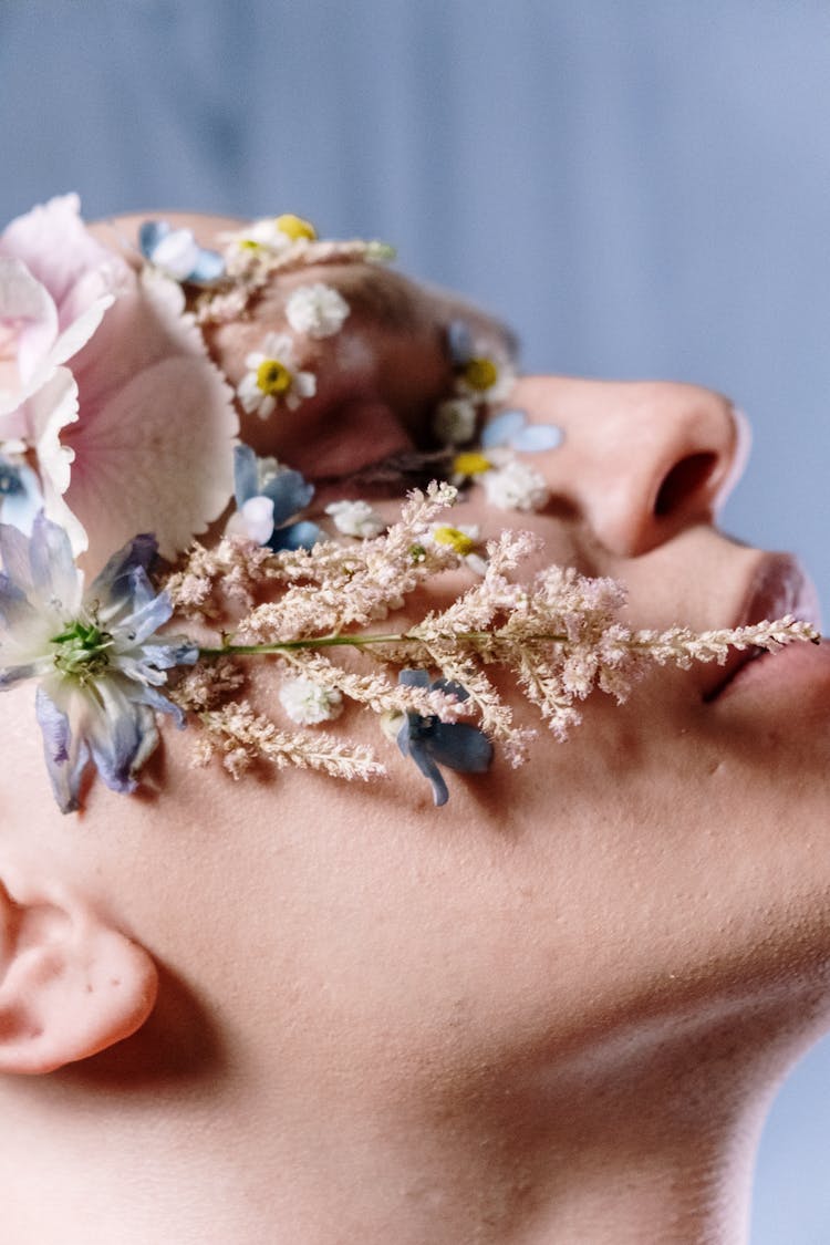 Woman With White And Blue Flower On Her Ear