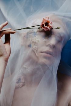 一幅以花卉妆容装饰的创意肖像，被透明面纱框住，散发着优雅与精致