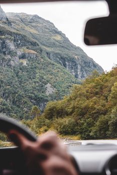 Experience a breathtaking road trip view of lush green mountains in Norway.