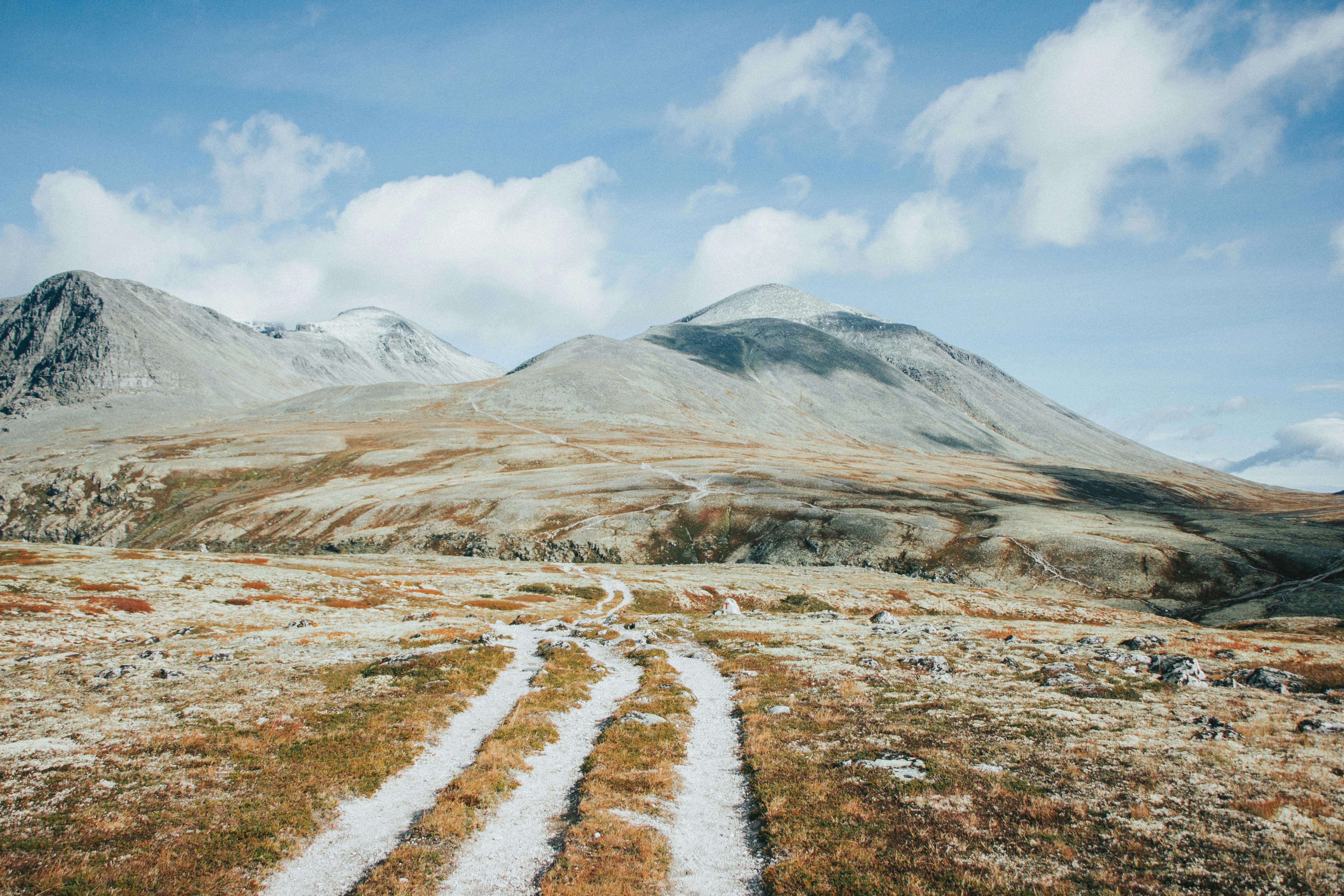 Unpaved trail leading through the rugged beauty of Norway's Rondane National Park mountains.