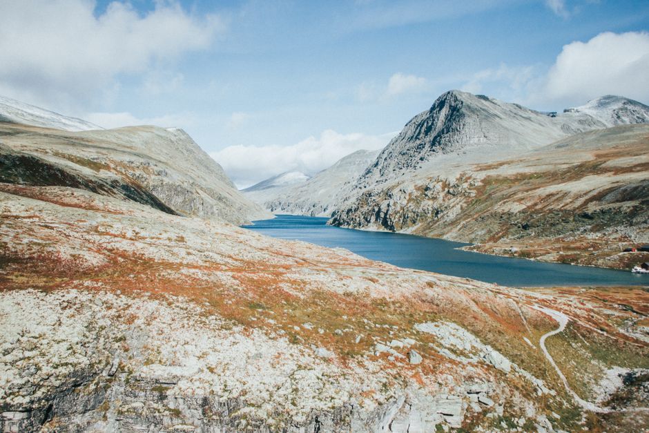 Discover the serene beauty of Norway's rugged mountains and tranquil lake.