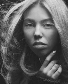 Striking black and white portrait of a woman with flowing hair, capturing elegance and poise.