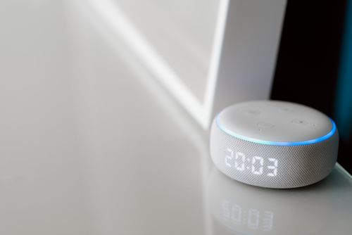 Free Close-up of a smart speaker with a digital clock display on a minimalist surface. Stock Photo