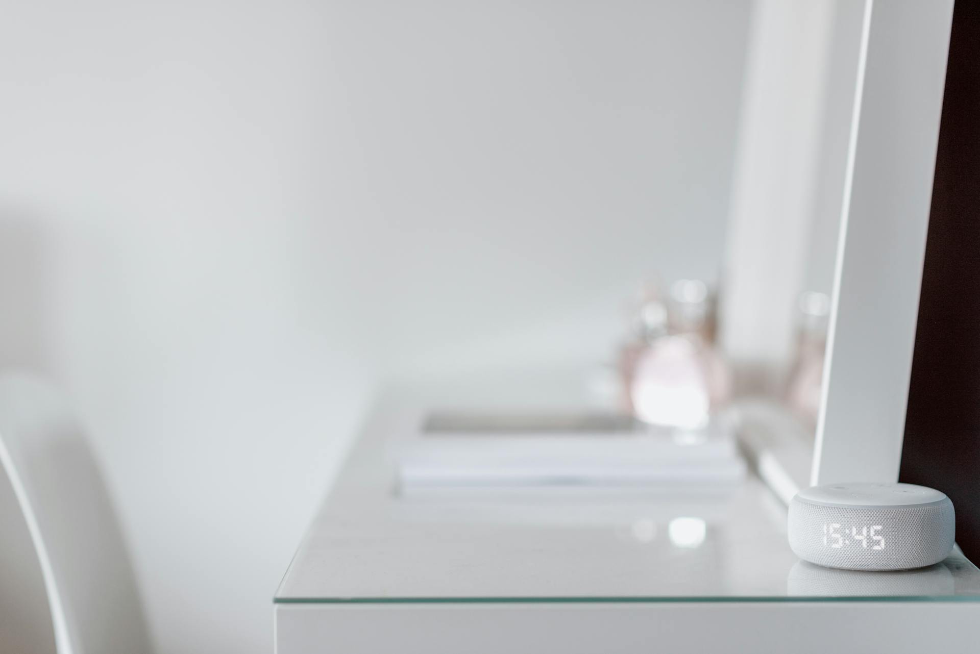 A sleek smart speaker on a minimalist desk with ample copy space, conveying modern simplicity.