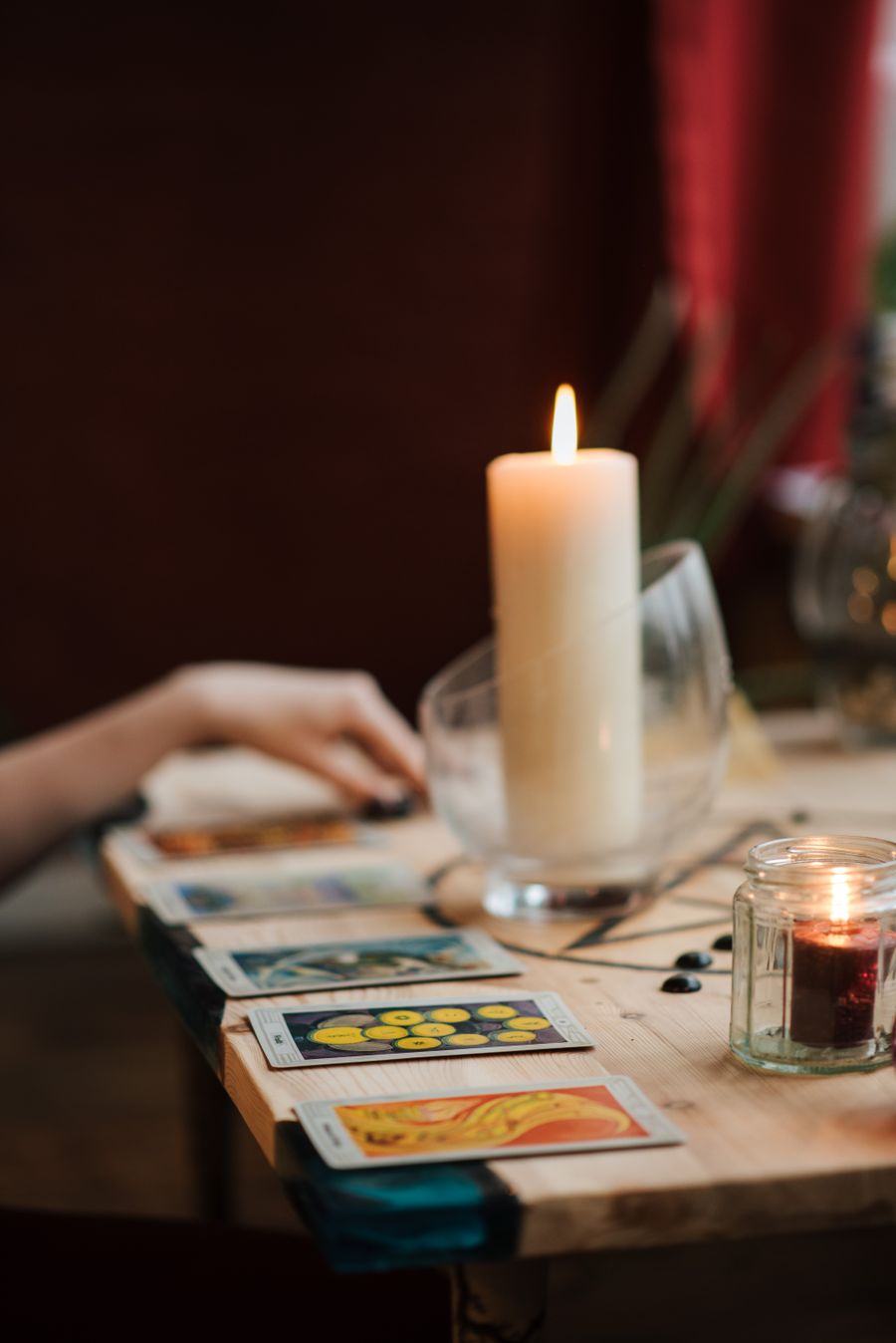 A beginner's first row of cards laid beside a candle