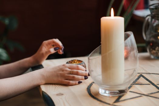 Crop soothsayer predicting fate with burning candle in house