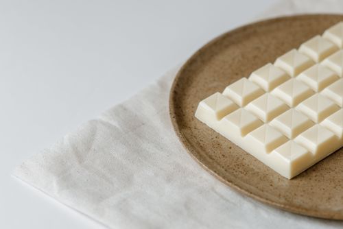 Free High angle of modern ceramic plate with bar of white chocolate on table Stock Photo